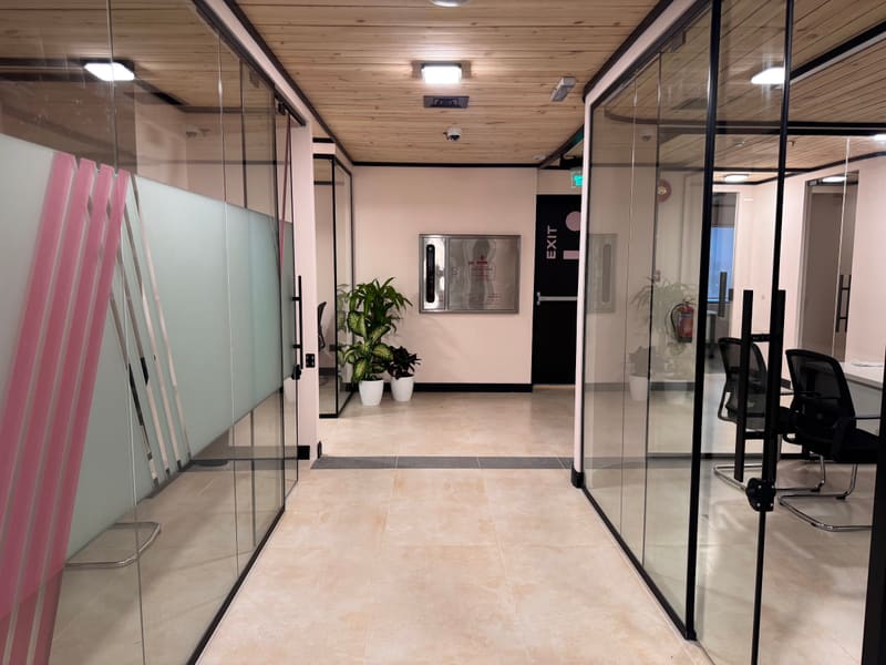 Glazed private offices along a corridor